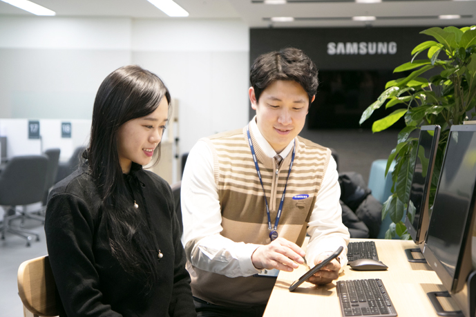 엔지니어가 고객에게 휴대폰사용방법을 설명하는 모습