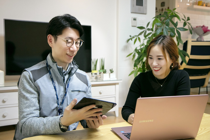 엔지니어가 고객에게 휴대폰사용방법을 설명하는 모습