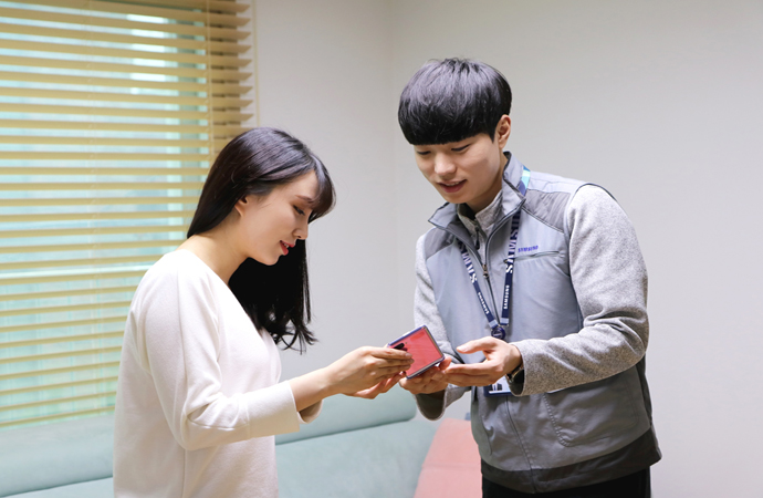 삼성전자서비스 수리엔지니어가 휴대폰방문서비스를 신청한 고객의 집을 방문해 점검을 마친 갤럭시-Z플립을 건네주고 있는 모습