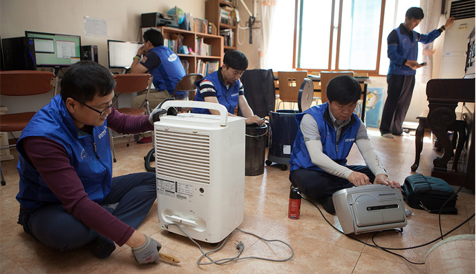 전자제품을 무상으로 점검해주는 재능기부 활동중인 임직원 사진 전자제품을 무상으로 점검해주는 재능기부 활동중인 임직원 사진